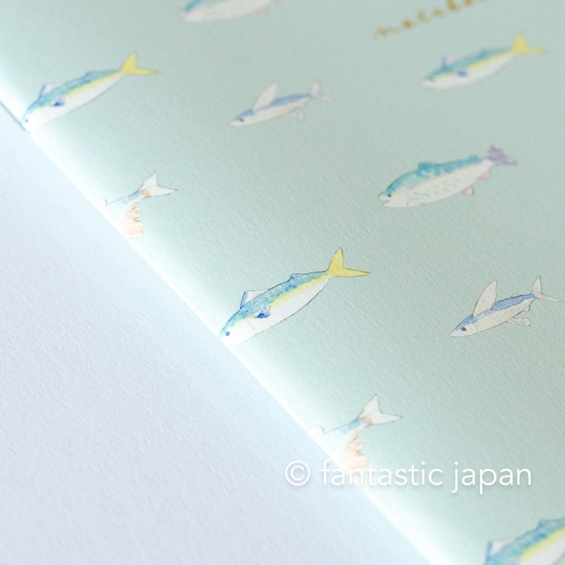 May include: A light blue paper with a repeating pattern of watercolor fish in shades of blue, yellow, and white. The fish are swimming in various directions. The text "&copy; fantastic japan" is in the bottom right corner.