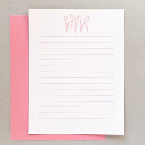 Puede incluir: Papel blanco con l&iacute;neas y un borde rosa, con un contorno rosa de cinco tulipes en la parte superior.