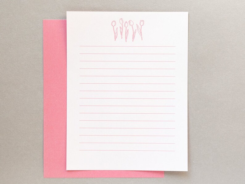 Puede incluir: Papel blanco con l&iacute;neas y un borde rosa, con un contorno rosa de cinco tulipes en la parte superior.