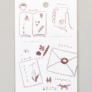 May include: A sheet of brown and white decorative stickers with illustrations of a cup of coffee, a book, a phone, a letter, a flower, a butterfly, a clover, a pen, a card, a fox, and trees. The stickers are labeled "Note", "Phone", "Letter", "Cand", and "enjoy!"