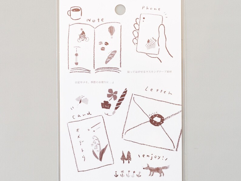 May include: A sheet of brown and white decorative stickers with illustrations of a cup of coffee, a book, a phone, a letter, a flower, a butterfly, a clover, a pen, a card, a fox, and trees. The stickers are labeled "Note", "Phone", "Letter", "Cand", and "enjoy!"
