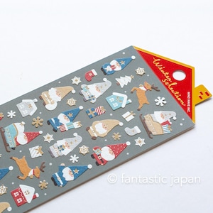 Puede incluir: Una hoja de pegatinas navideñas con diseños de Papá Noel, renos y copos de nieve. Las pegatinas son de varios colores, incluyendo rojo, azul y beige, sobre un fondo gris. El texto "Winter Selection" es visible.