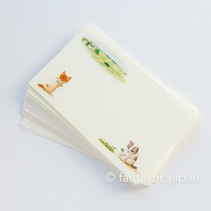 May include: A stack of cream-colored stationery featuring watercolor illustrations of playful kittens and a rural landscape. The stationery has a delicate, artistic feel, with the text "fantastic japan" at the bottom.