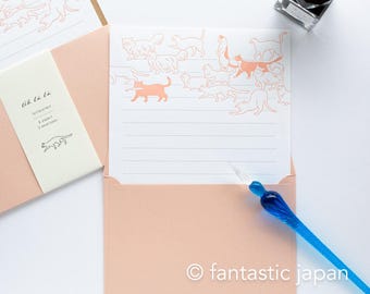 May include: A set of pink stationery with a white envelope and a sheet of paper with a line drawing of cats in pink. The paper has a light pink border and the text "Oh la la" in black. The text "Letterpress / 8 papers / 7 envelopes" is also in black.