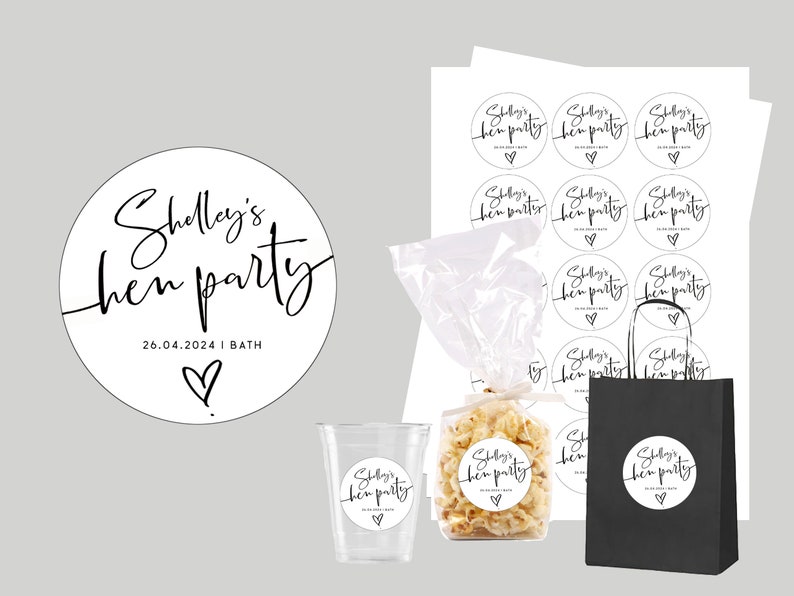 May include: A set of black and white round stickers with the text "Shelly's hen party 26.04.2024 | BATH" and a small heart. The stickers are on a white sheet of paper, a clear plastic bag, a clear plastic cup, a black paper bag, and a white paper bag.