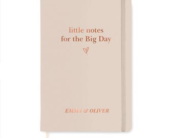 May include: A light beige notebook with a vertical elastic closure and a ribbon bookmark. The cover features the text "little notes for the Big Day" above a small heart icon, with the names "EMMA & OLIVER" printed in copper at the bottom.