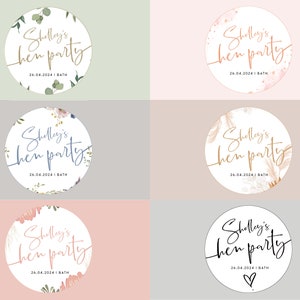 May include: Six round stickers with a white background and different floral designs. Each sticker has the text "Shelley's hen party" in black cursive script and the date "26.04.2024" and the word "BATH" in smaller black text.