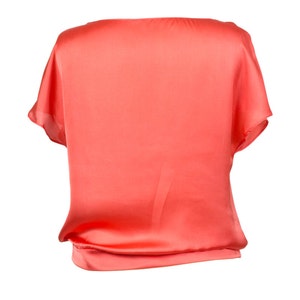 K&ouml;nnte beinhalten: Eine kurze, lockere Bluse aus Satin in Korallenfarbe.