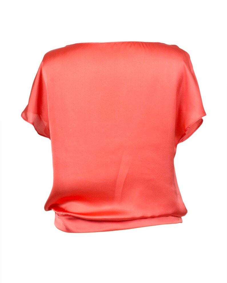 K&ouml;nnte beinhalten: Eine kurze, lockere Bluse aus Satin in Korallenfarbe.