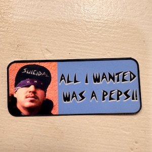 Könnte beinhalten: Ein rechteckiger Aufkleber mit einem Porträt eines Mannes mit einer schwarzen Kappe mit dem Wort "SUICIDAL" und einem lila Bandana. Die rechte Seite ist hellblau mit dem Text "ALL I WANTED WAS A PEPSI!!".