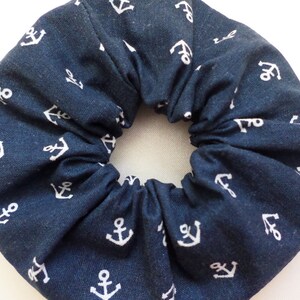 Op de afbeelding: Een marineblauwe scrunchie met een wit ankerpatroon.