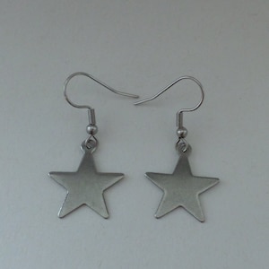 May include: A pair of silver star-shaped earrings with a simple hook design.