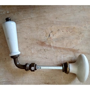 Old pair of white porcelain and brass door handles