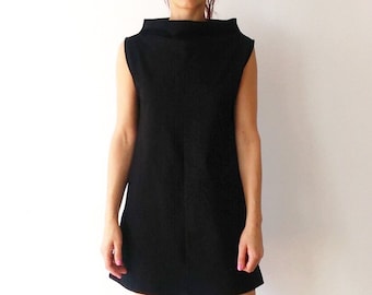 Vestido negro corto con cuello alto y escote alto: vestido de invitada de boda.