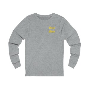 May include: Gray long-sleeve shirt with a yellow embroidered design that says "Boca Bitch".