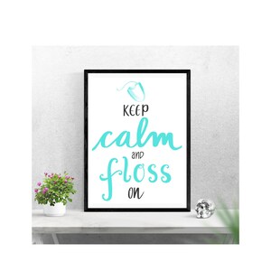 Könnte beinhalten: Ein gerahmter Druck mit schwarzem Rahmen und weißem Hintergrund. Der Druck zeigt eine türkisblaue Illustration von Zahnseide mit dem Text "Keep calm and floss on".