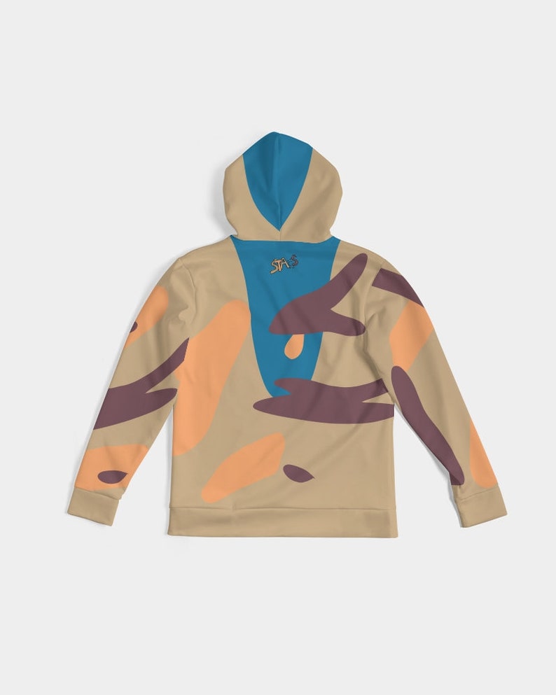 Puede incluir: Sudadera con capucha color beige con capucha y panel trasero azules, con formas abstractas naranjas y marrones. La parte trasera de la capucha tiene un peque&ntilde;o logotipo. Mangas largas con patrones abstractos a juego. Prenda casual y c&oacute;moda.