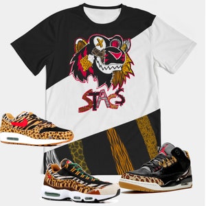 Puede incluir: Una camiseta de color blanco y negro con un gr&aacute;fico de tigre y la palabra "STAG" impresa en ella. Tambi&eacute;n se muestran tres pares de zapatillas con un dise&ntilde;o de estampado de leopardo.