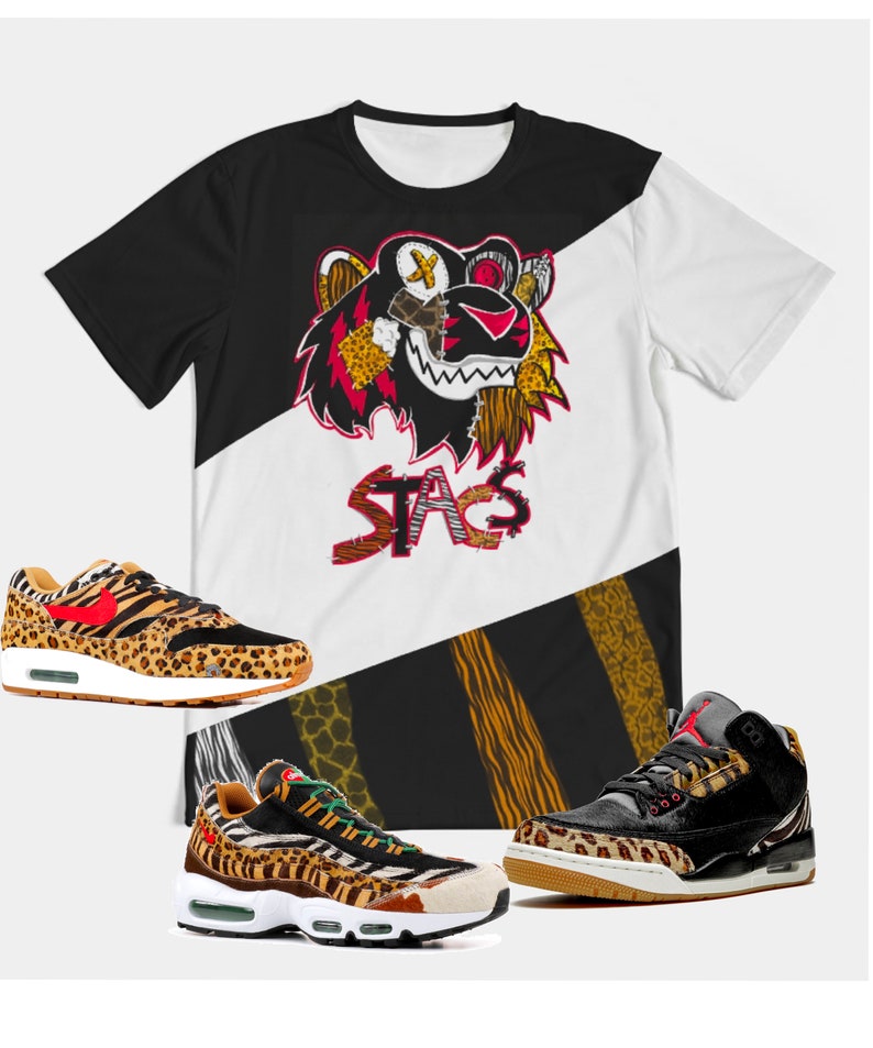Puede incluir: Una camiseta de color blanco y negro con un gr&aacute;fico de tigre y la palabra "STAG" impresa en ella. Tambi&eacute;n se muestran tres pares de zapatillas con un dise&ntilde;o de estampado de leopardo.