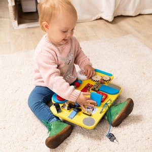 Children play with wooden board. The perfect toy for developing fine motor skills. Suitable for girls and boys aged 1.5 - 2 years old and up.