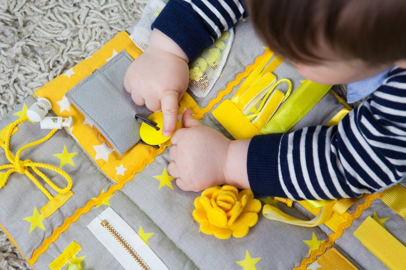Children play with a blanket. The perfect toy for developing fine motor skills
