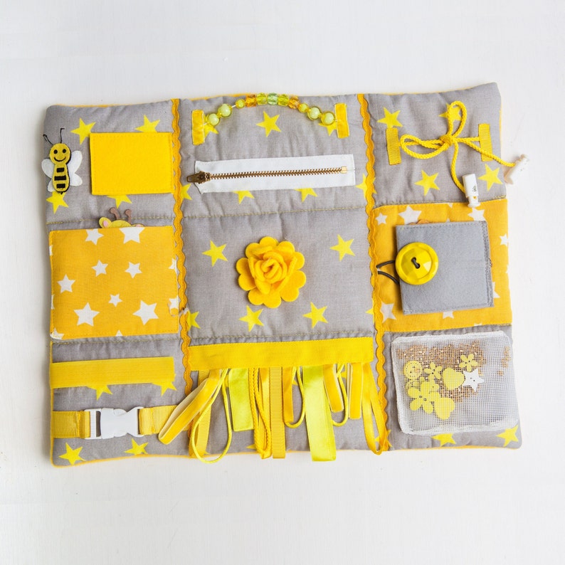 Yellow handmade cotton sensory blanket. Size 30x40cm (12x15 in) is very comfortable for tummy time. Quite fluffy and very soft. On the front part of the mat there are different fidget elements: buttons, beads, ribbons, felt decorations, ties etc