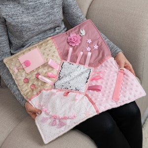 Interesting activities for tactile stimulation:  felt decoration, door with lock. Colorful Tassel pendants. Ribbons with items to plait. 
Textile hook & loop fastener. Reversible Sequins. All items are securely attached to each other.