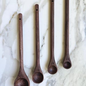 This hand carved measuring spoon set includes four spoons- a tablespoon, teaspoon, 1/2 teaspoon, and 1/4 teaspoon. This is a practical kitchen gift, a unique kitchen gift, and also works great as a coffee scoop and tea spoon.