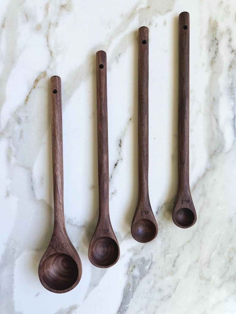 This hand carved measuring spoon set includes four spoons- a tablespoon, teaspoon, 1/2 teaspoon, and 1/4 teaspoon. This is a practical kitchen gift, a unique kitchen gift, and also works great as a coffee scoop and tea spoon.