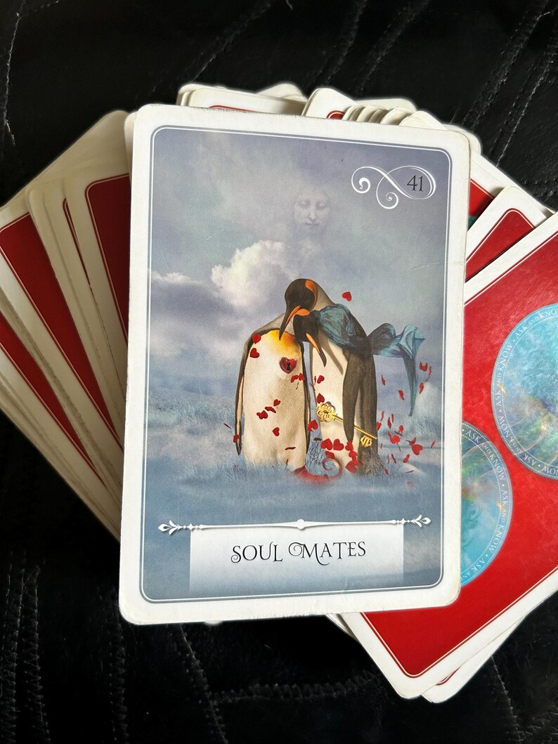 May include: A tarot card with a blue background and two penguins standing on a snowy surface. The card is numbered 41 and the word "Soul Mates" is printed on the bottom. Red hearts are scattered around the penguins.