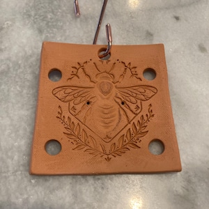 May include: A set of three ceramic mugs with a speckled, matte finish. The mugs are in shades of cream, light gray, and dark gray. Each mug has a simple, minimalist design and a rounded handle. Perfect for coffee or tea.