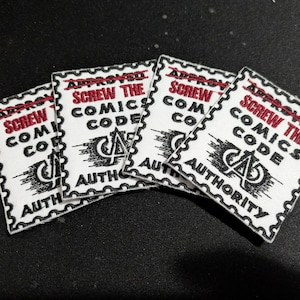 May include: Four white patches with black and red text that reads "APPROVED SCREW THE COMICS CODE AUTHORITY". The patches have a postage stamp design with a black border and a crossed-out line above the text.