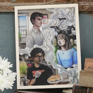 Puede incluir: Una pintura de acuarela de tres personas en una cocina. La persona de la izquierda lleva una camisa blanca y tiene el pelo oscuro. La persona del medio lleva una camisa negra con un gráfico y sostiene una espátula. La persona de la derecha lleva una camisa azul y tiene el pelo largo y castaño. Hay humo saliendo de la estufa y la pintura está sobre un fondo blanco.