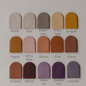 May include: A color chart with 15 different paint colors in a semi-circle shape. The colors are labeled with German names, including Vanille, Kalk, Kieselstein, Helles Gelb, Senfgelb, Cognac, Helles Rosa, Altrosa, Zimt, Mauve, Kastanie, Merlot, Helles Lila, Dunkles Lila, and Lavendel.