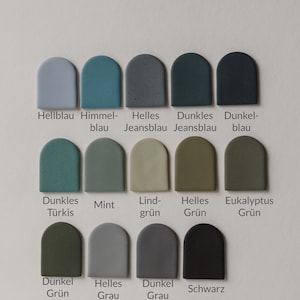 May include: Color chart with 12 paint swatches in various shades of blue, green, and gray. The swatches are arranged in three rows of four. Each swatch is labeled with a German word describing the color.