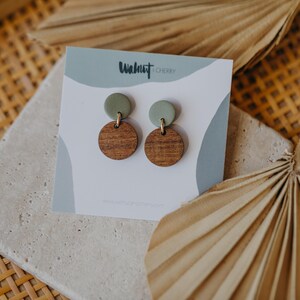 May include: A pair of green and brown wooden earrings with the text "Walnut & Cherry" on the card.