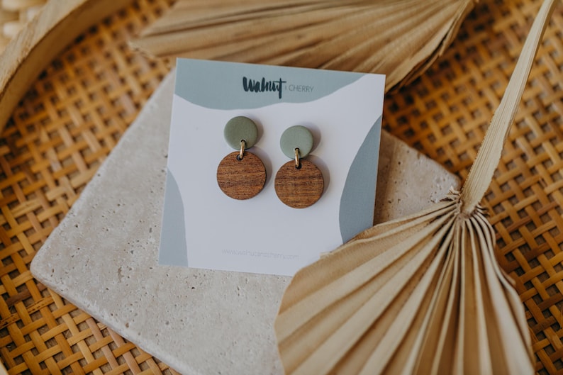 May include: A pair of green and brown wooden earrings with the text "Walnut & Cherry" on the card.