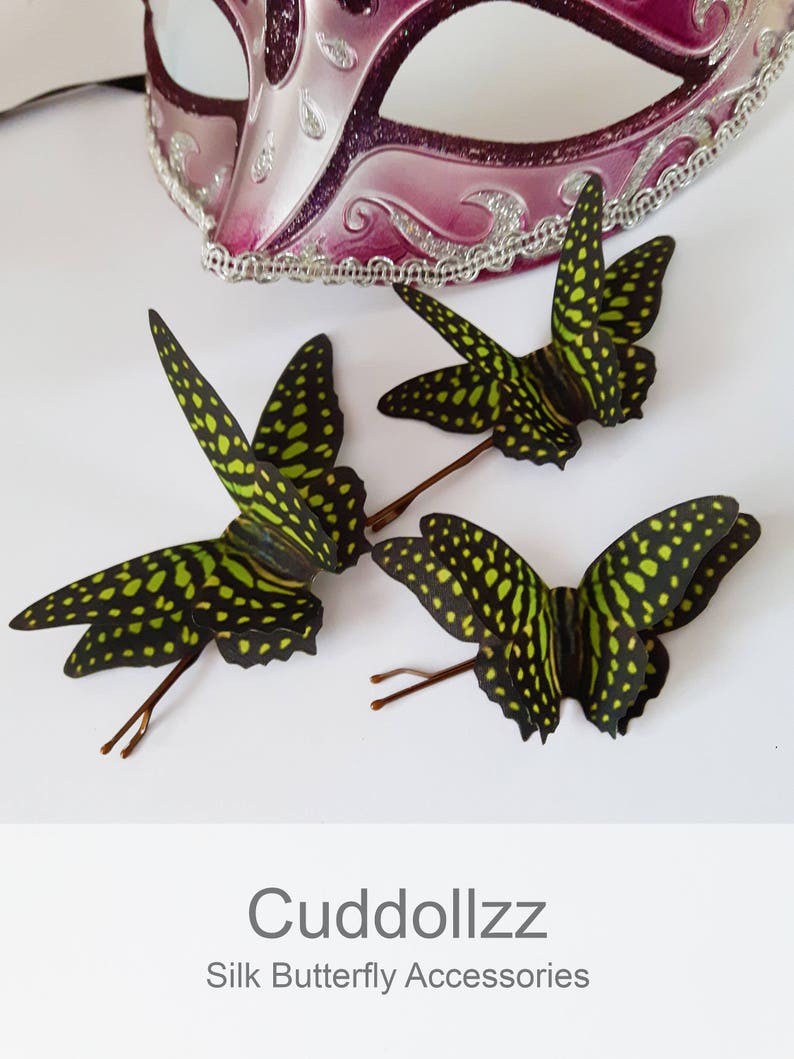 May include: Three green and black silk butterfly hair clips. The butterflies have a spotted pattern and are attached to bobby pins.