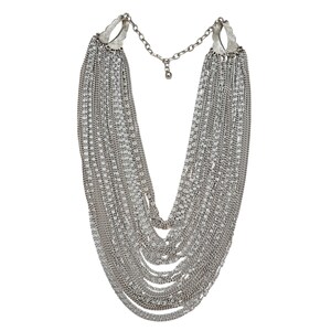May include: Silver-toned statement necklace featuring multiple strands of delicate chains cascading from two ornate, textured clasps. The necklace has a layered design, creating a bold, eye-catching accessory. The chains are connected by a smaller chain with an adjustable clasp.