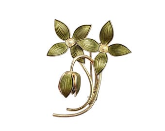 May include: A silver and green enamel floral brooch featuring two flowers and a bud. The flowers have a yellow center with a white dot.