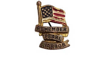 May include: A vintage pin featuring the American flag with red, white, and blue enamel. The pin includes a banner with the words "REMEMBER PEARL HARBOR" in raised lettering. The pin has a gold-tone finish and is likely made of metal.