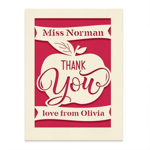 May include: A red card with a white apple cut out. The apple has the words "THANK YOU" inside. The card says "Miss Norman" at the top and "love from Olivia" at the bottom.