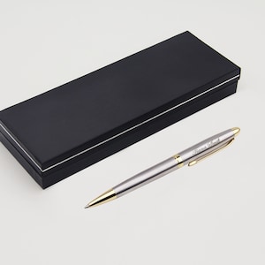 May include: A silver pen with a gold trim and a black gift box. The pen has the name "Diana Smith" engraved on it.