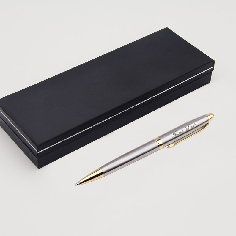 May include: A silver pen with a gold trim and a black gift box. The pen has the name "Diana Smith" engraved on it.