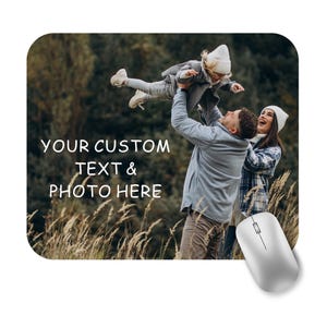 May include: A custom mouse mat featuring a family photograph. The image shows a family with a child being held aloft. The text "YOUR CUSTOM TEXT & PHOTO HERE" is printed on the mouse mat.