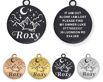 May include: Five dog tags with a mountain and moon design. The tags are black, silver, gold, and rose gold. The text on the black tag reads "IF IAM OUT ALONE I AM LOST PLEASE FIND MY OWNER LUKE 07778553337 36 LUONDON RD EX4 2EE". The other tags have the name "Roxy" engraved on them.