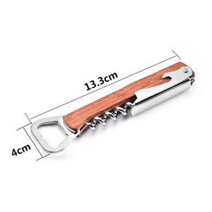 May include: A silver and wooden bottle opener with a corkscrew and a bottle cap opener. The opener is 13.3 inches long and 4 inches wide.