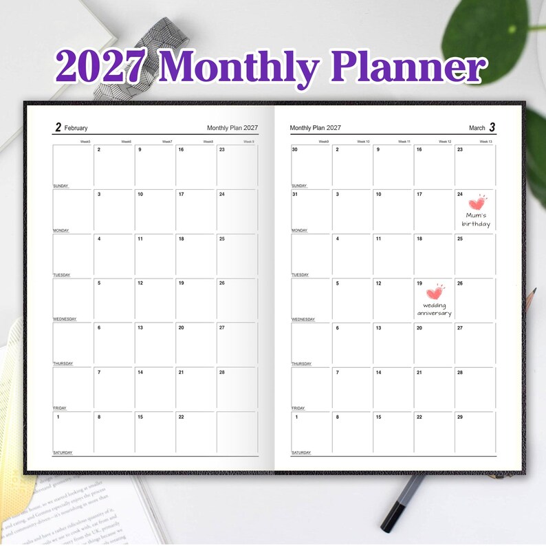 May include: A 2027 monthly planner open to February and March. The pages feature a grid layout with days of the week, dates, and blank squares. Two small pink heart icons are visible on the March calendar, with text reading Mum's birthday and wedding anniversary.