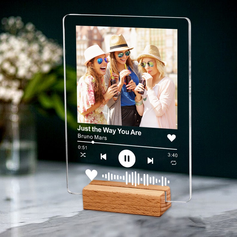 May include: A clear acrylic music plaque featuring a photo of three women and the song title "Just the Way You Are" by Bruno Mars. The plaque is displayed on a wooden stand, with a music waveform graphic.