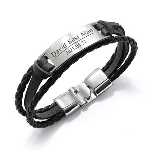 May include: Black leather bracelet with a silver metal clasp and a rectangular silver plate engraved with the text "David Best Man 2021.06.21".
